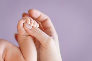 Newborn children's hand in mother hand. Mom and her Child. Happy Family concept. Beautiful conceptual image of Maternity