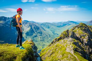 Woman climber on mountain ridge overlooking Glen Coe Highlands Scotland